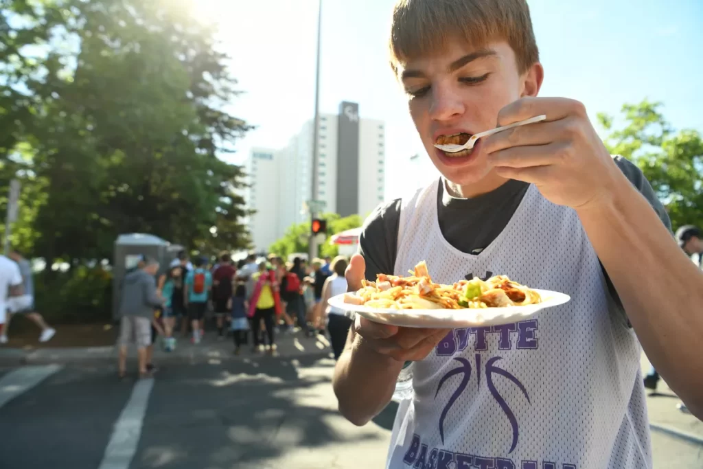Kid Eating Food from a Vendor at Hoopfest