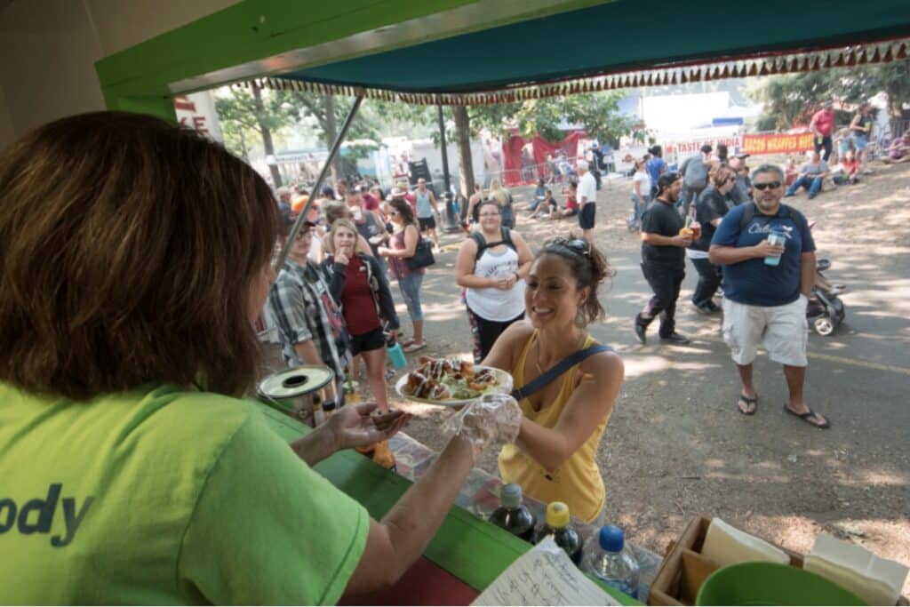 Vendor handing out food at pig out in the park