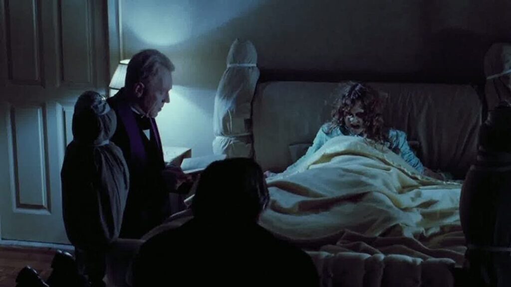 Priest looking over possessed girl in bed in the Halloween Movie the Exorcist