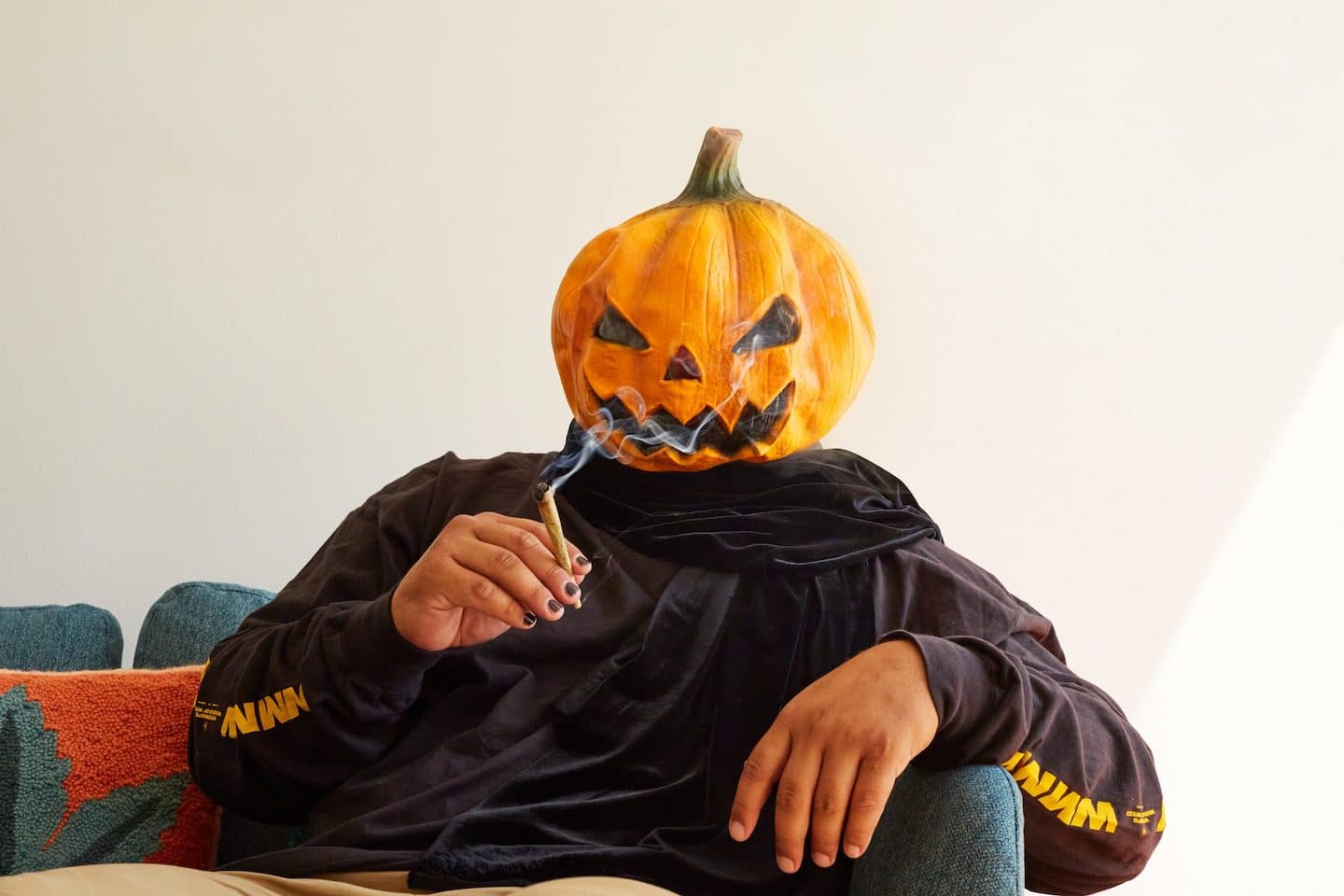 Person with a Jack O Lantern Pumpkin Head Smoking a Joint