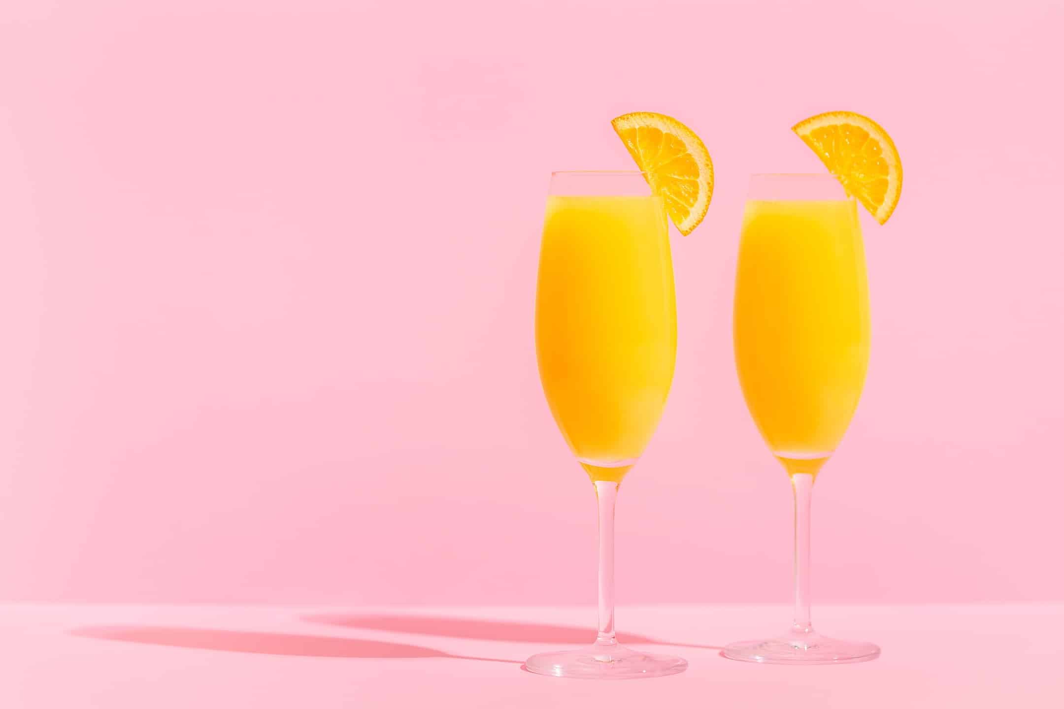 Mimosa Cocktails on a Pink Backdrop to Represent the Cannabis Strain Mimosa