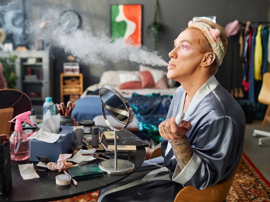 Person Doing Makeup While Blowing Smoke