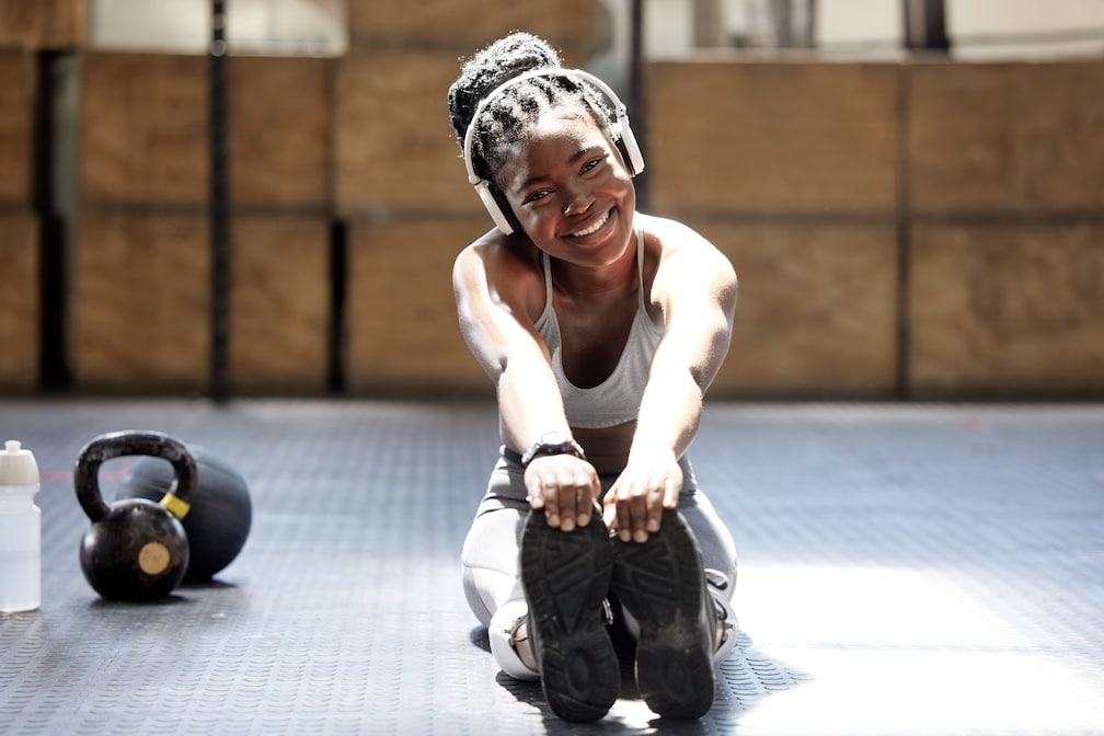 Portrait, black woman and stretching while listening to music for fitness, health and wellness. 