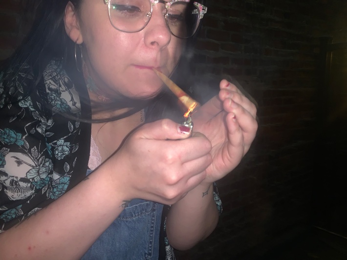 Girl Lighting Up a Rose Petal Joint