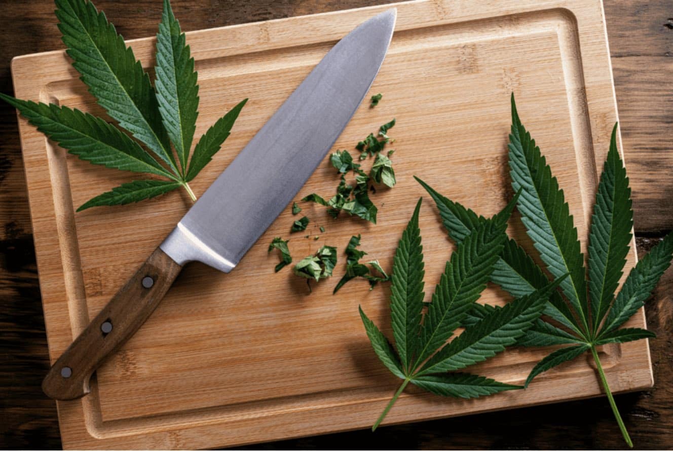 Cannabis Leaves on a Cutting Board With a Knife