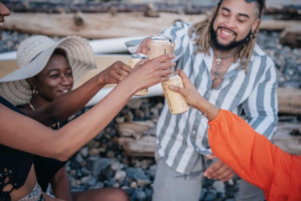 People Clinking Cans Together in a Toast
