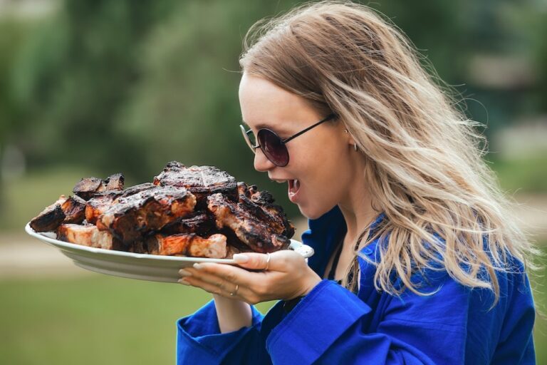 Person holding a plate of ribs