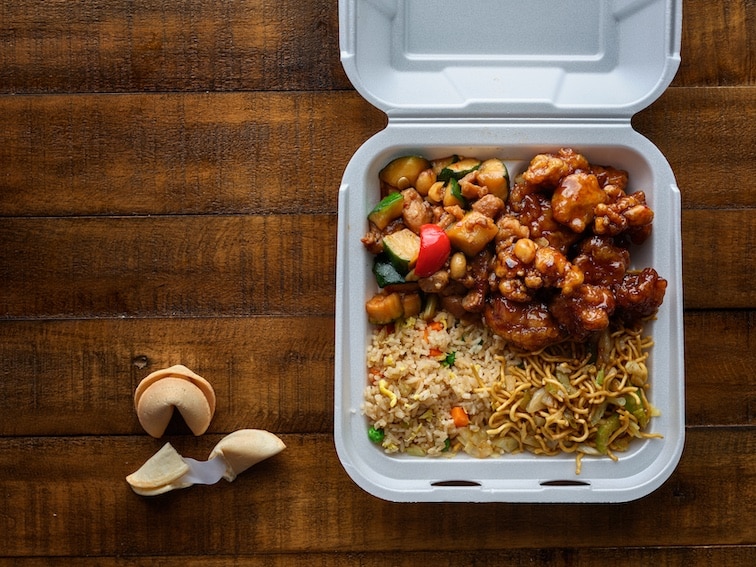 Chinese take out with fried rice and general tsos chicken on table top