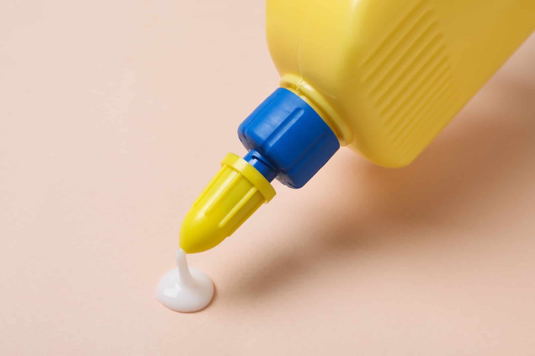 Glue being squeezed out of yellow bottle