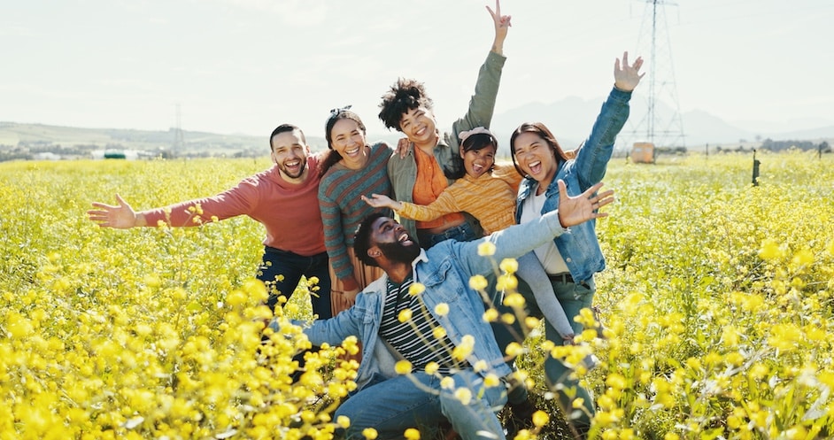 Friends Looking Joyous With Outstretched Arms in a Flower Field