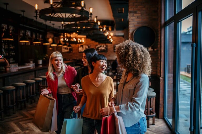 Four women, possibly colleagues or friends, are leaving a restaurant, happily chatting after a pleasant meal and shopping