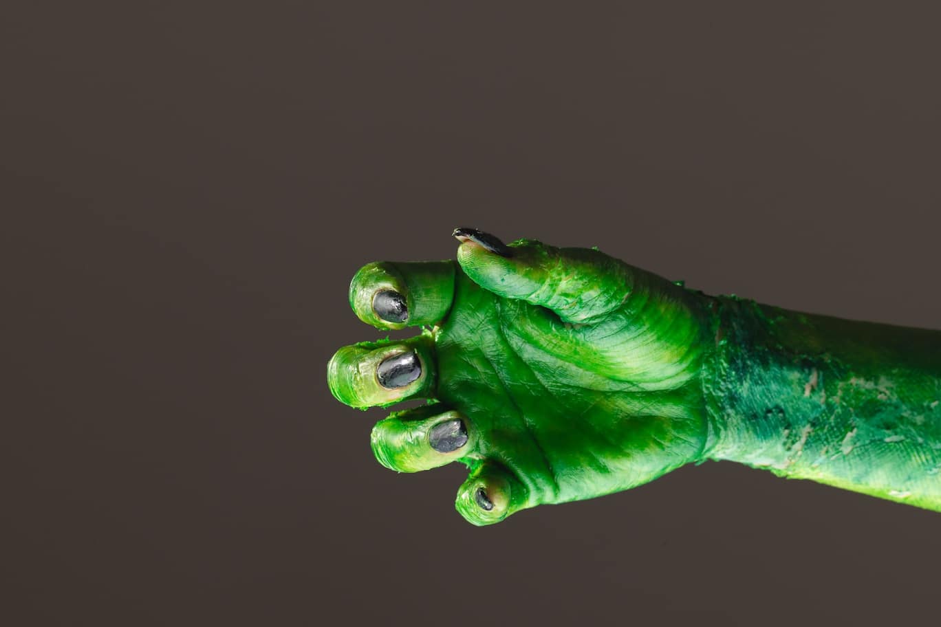 Green Frankenstein monster hand reaching from the right