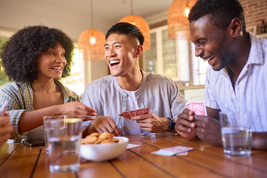 Friends smiling while playing a card game