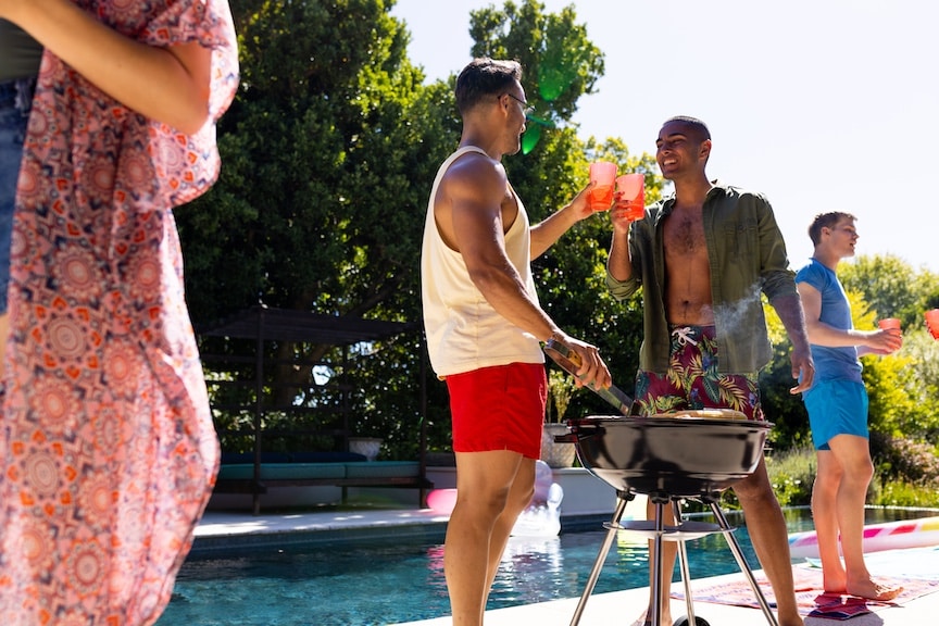 Friends hanging out by the pool and bbq in the summer