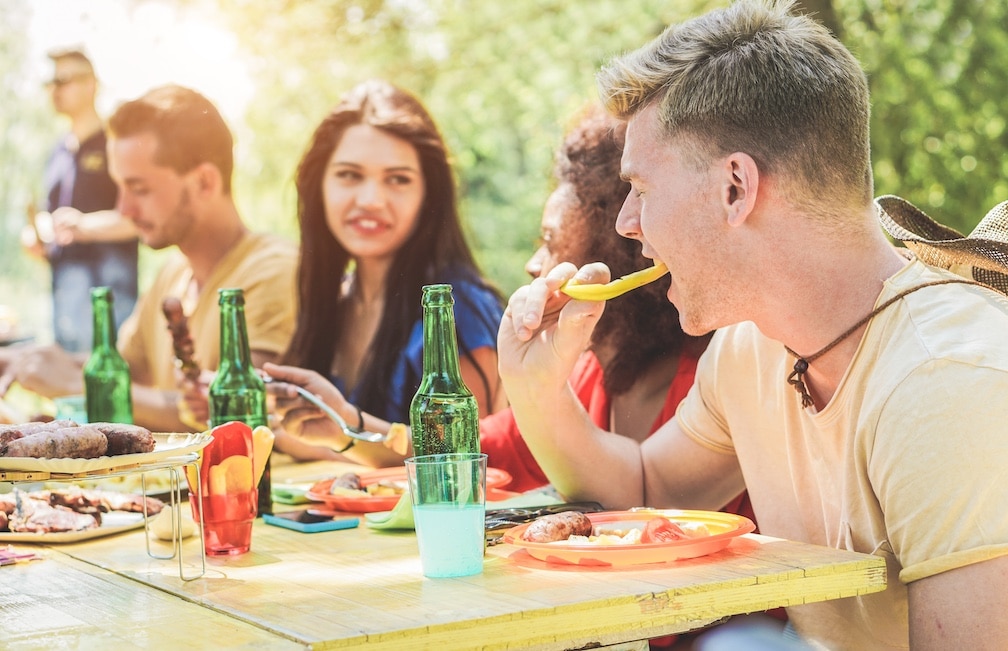 Young people at a table eating a drinking outside