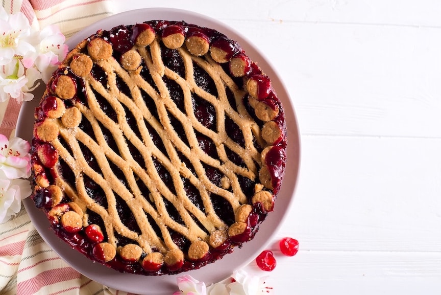 Homemade cherry pie on white wooden background
