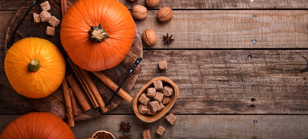 Pumpkin. Autumn food background with cinnamon, nuts and seasonal spices on rustic background. Cooking pumpkin or apple pie and cookies for Thanksgiving and autumn holidays