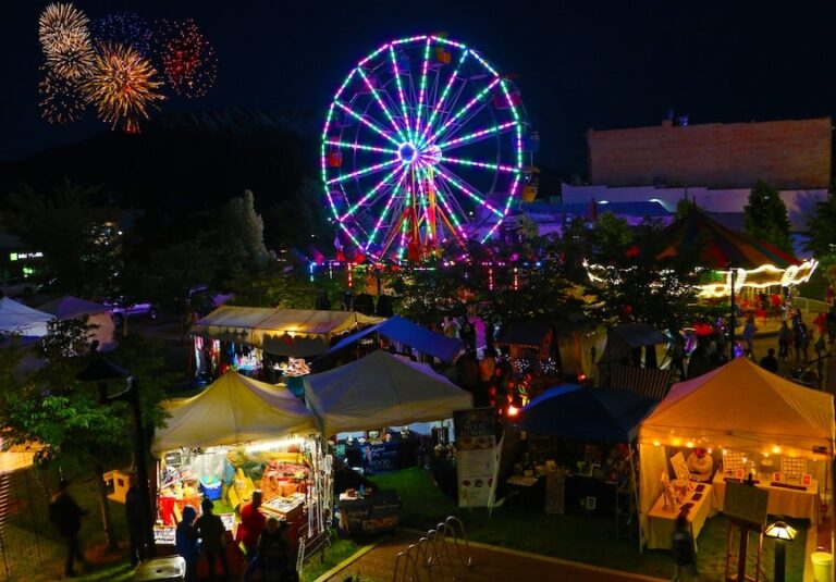 County fair featuring fireworks and ferris wheel at night