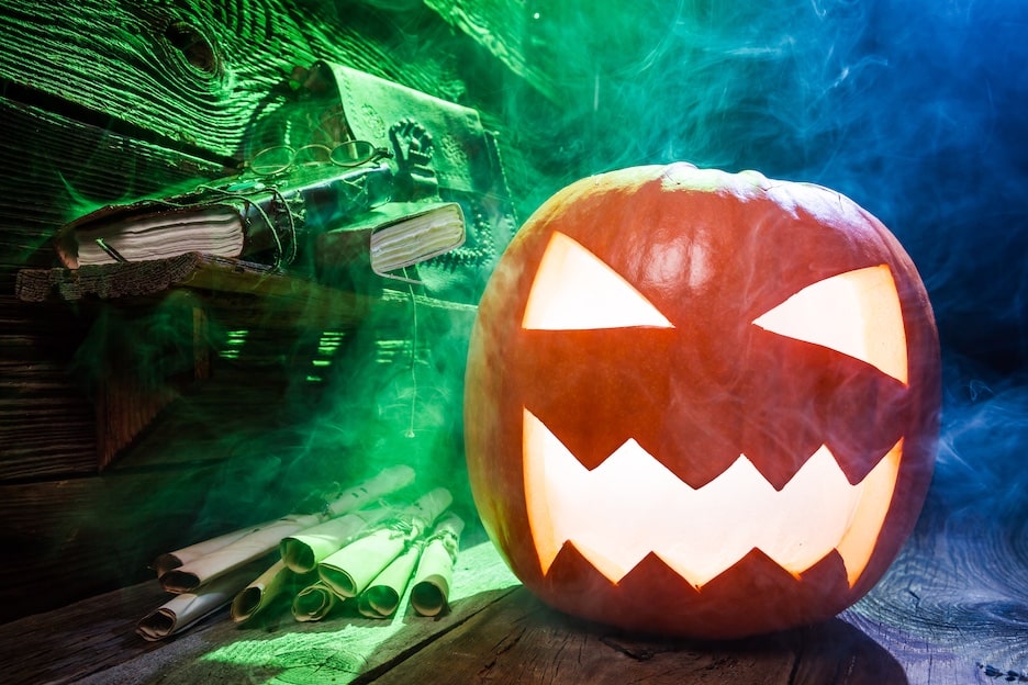 Jack o' Lantern in a spooky smokey room with green and blue lighting