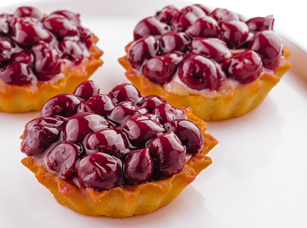 Small tarts with cherries on plate to represent the strain Cherry Fritter