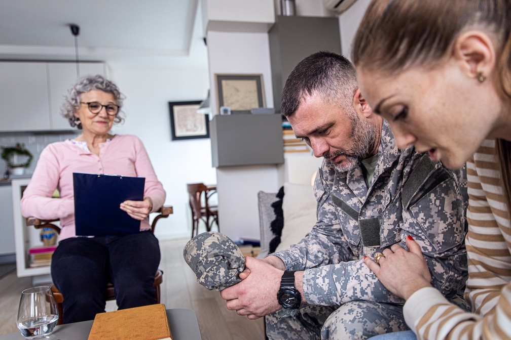 Soldier with his wife having therapy meeting with senior female psychologist