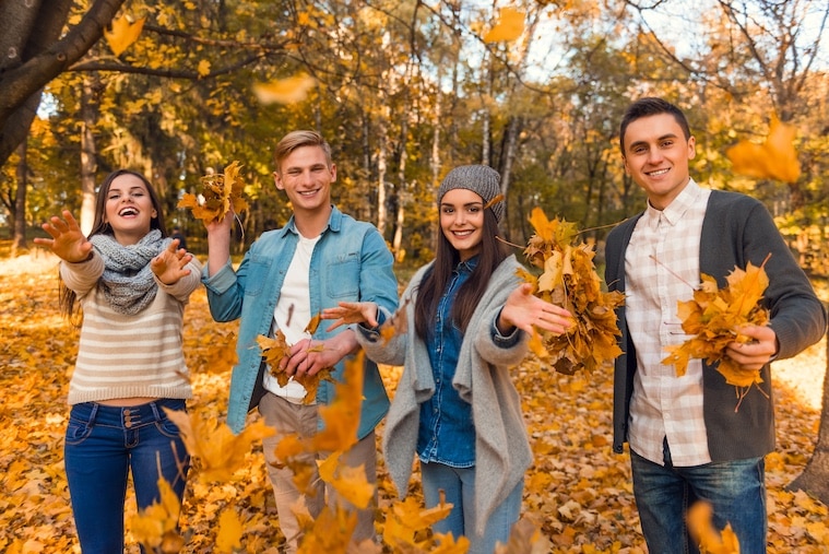 Group of People Playing in the Autumn Leaves