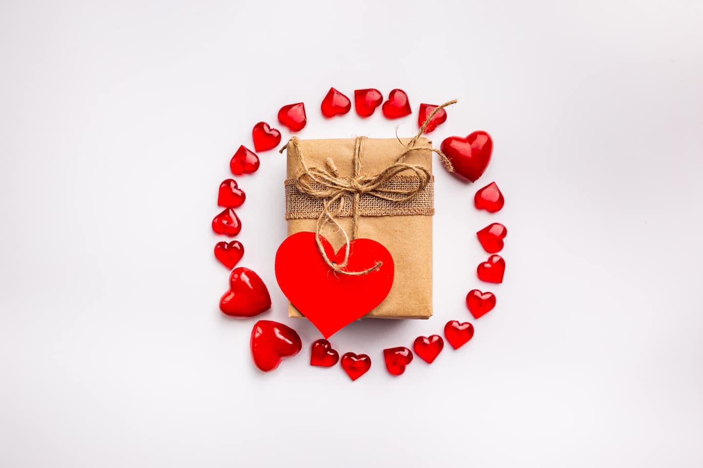 Red Hearts in circle shape with handmade gift box on abstract white background. Love concept for valentines day.