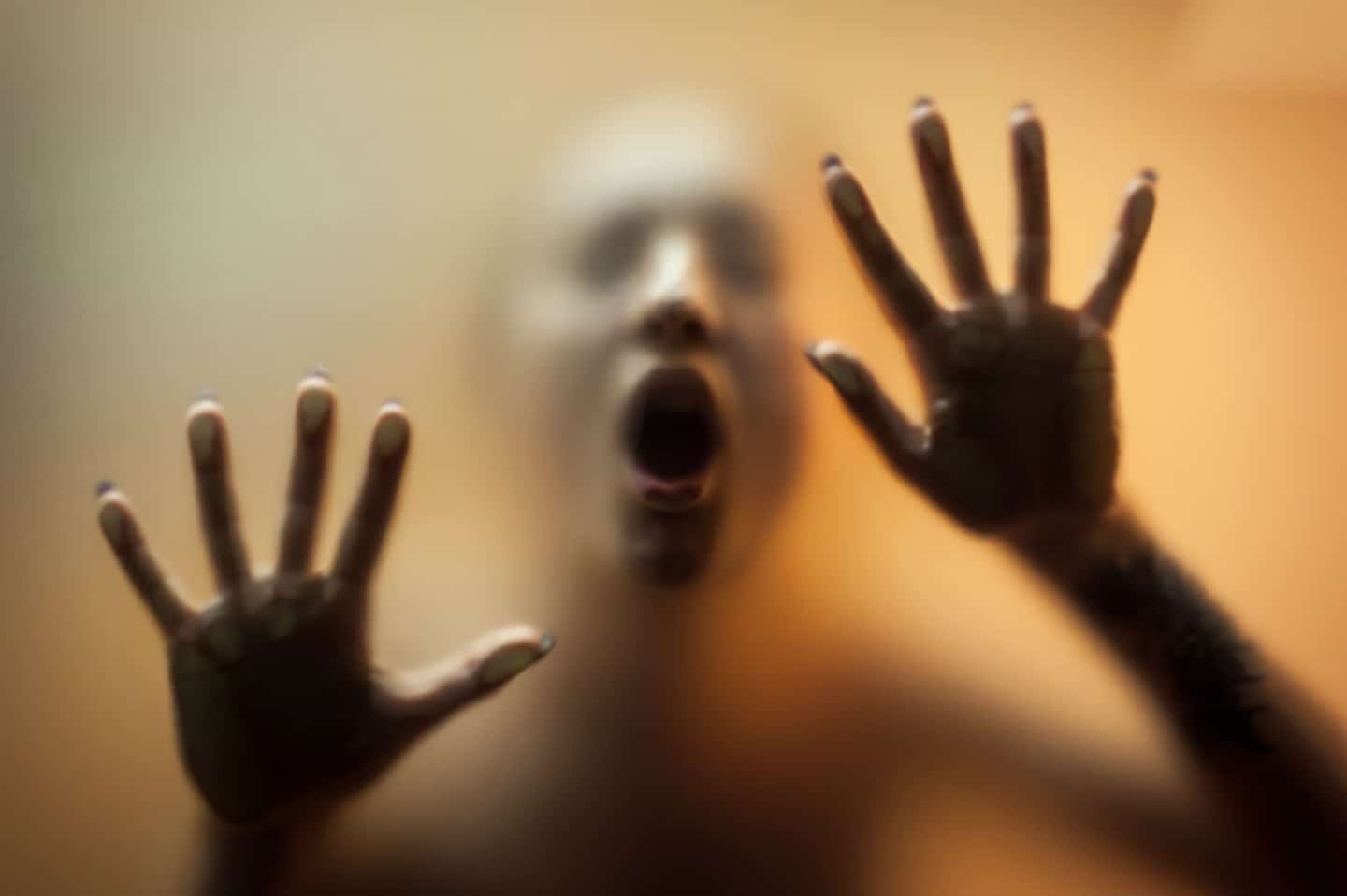 Scary nightmare image of person with hands against window